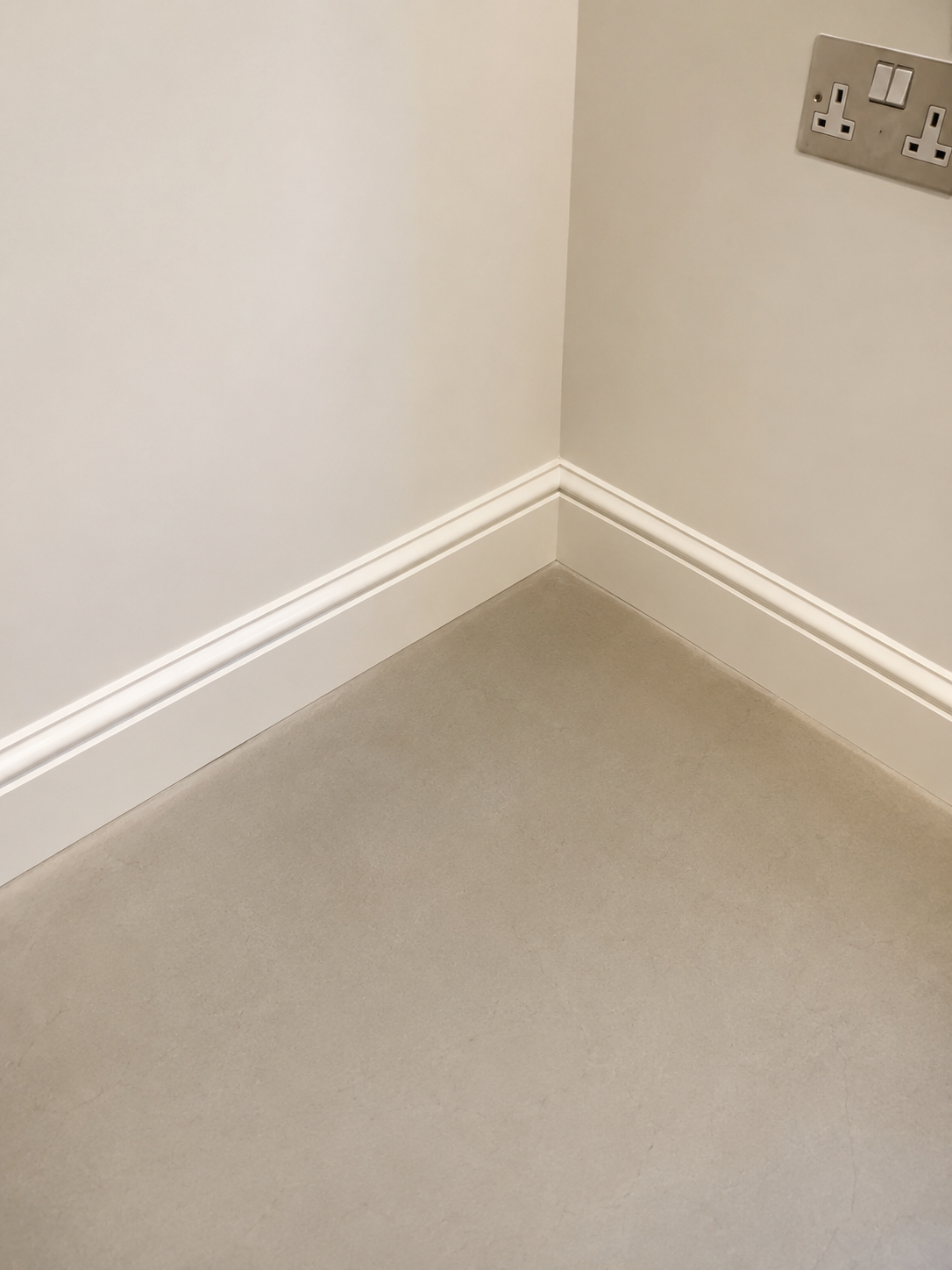 Clean repaired wall corner with finished skirting and floor.