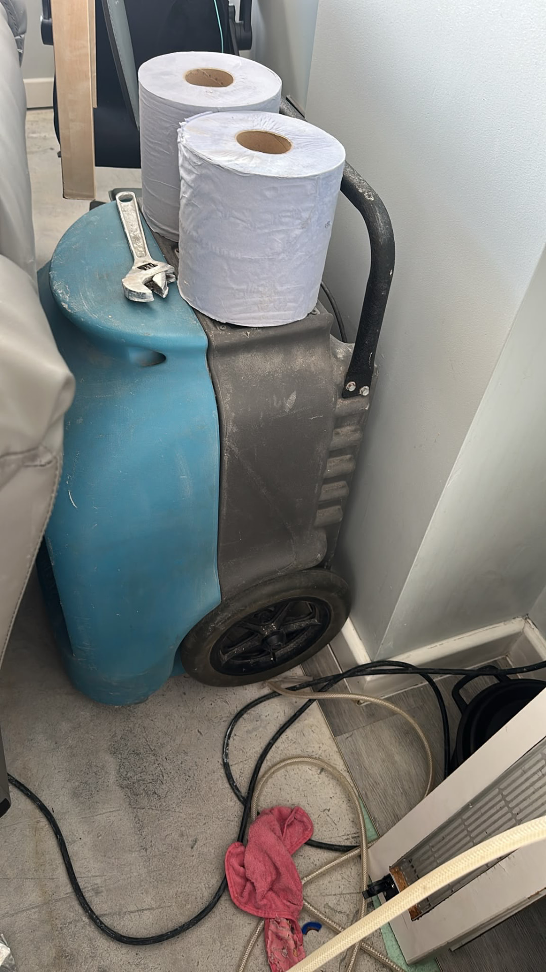 Professional dehumidifier positioned in a corner of the affected property during drying