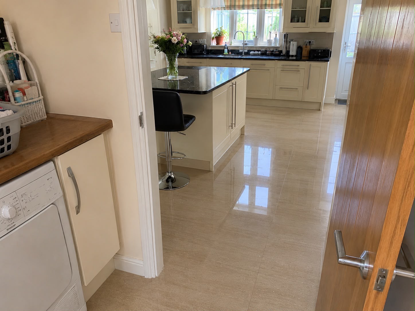 Restored kitchen with clean tiled floor viewed from the utility room doorway
