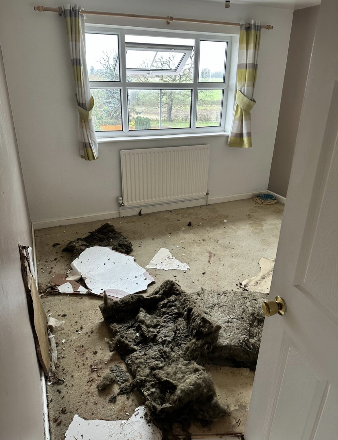 Bedroom with plasterboard removed and insulation exposed after water damage