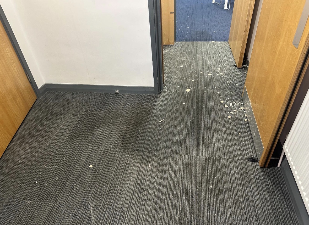 Commercial office corridor with debris following water damage.