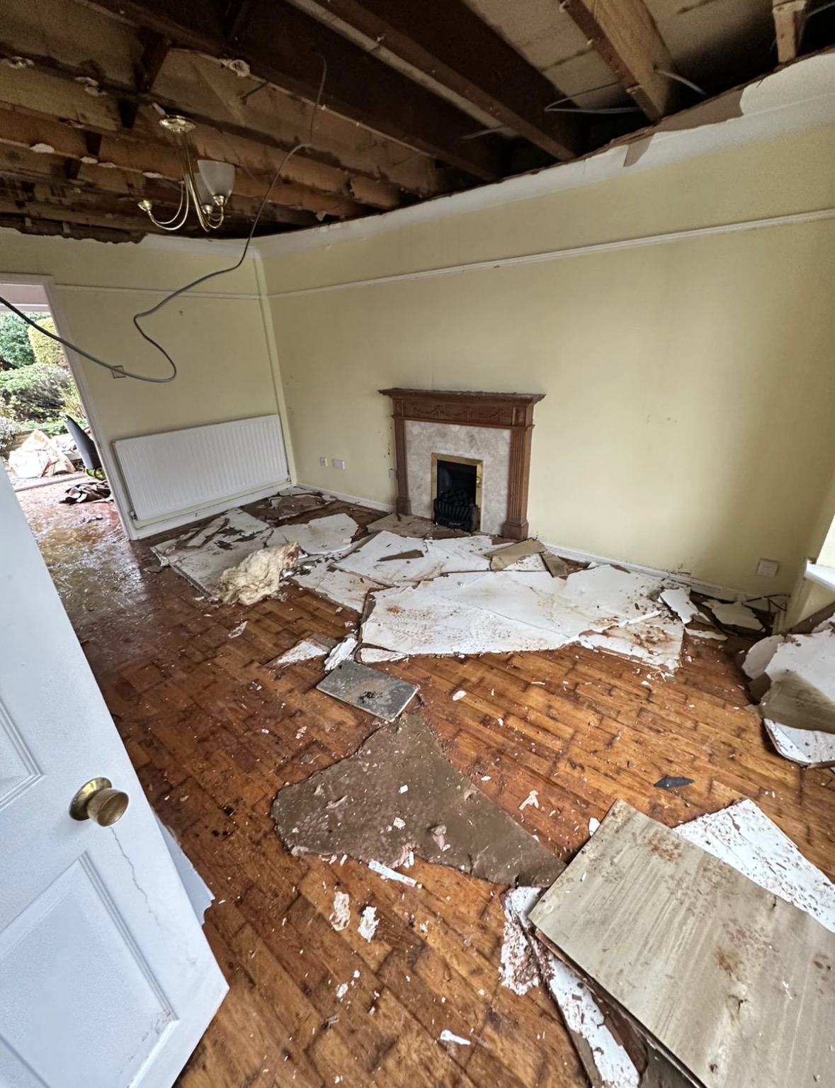 Living-room ceiling opened up to expose joists and remove water-damaged plasterboard