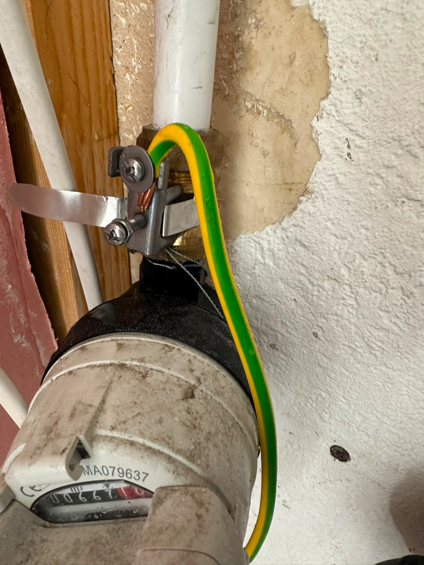 Pipework and water meter with tide staining on the adjacent wall