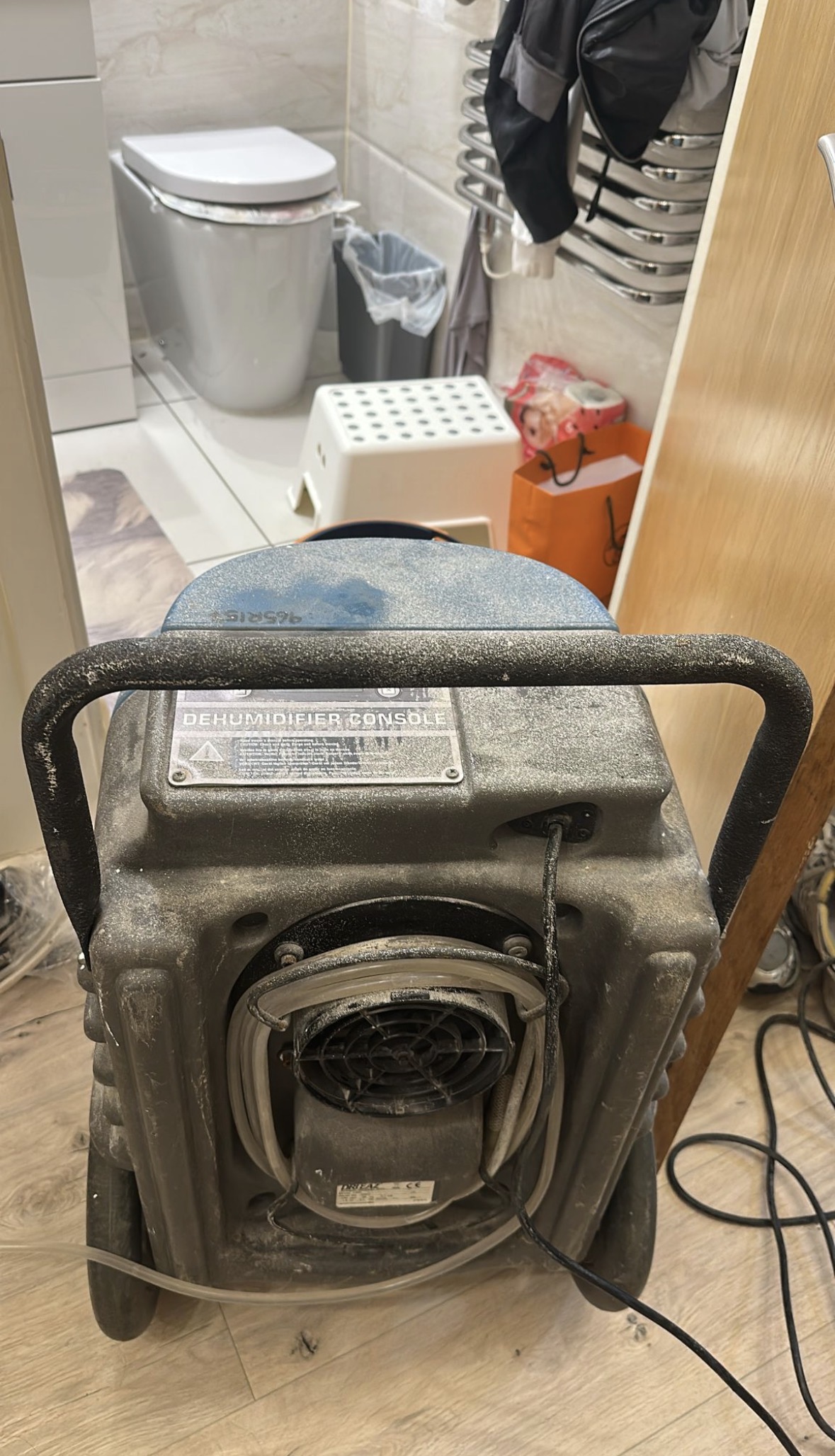 Rear of blue professional dehumidifier showing air intake and drainage