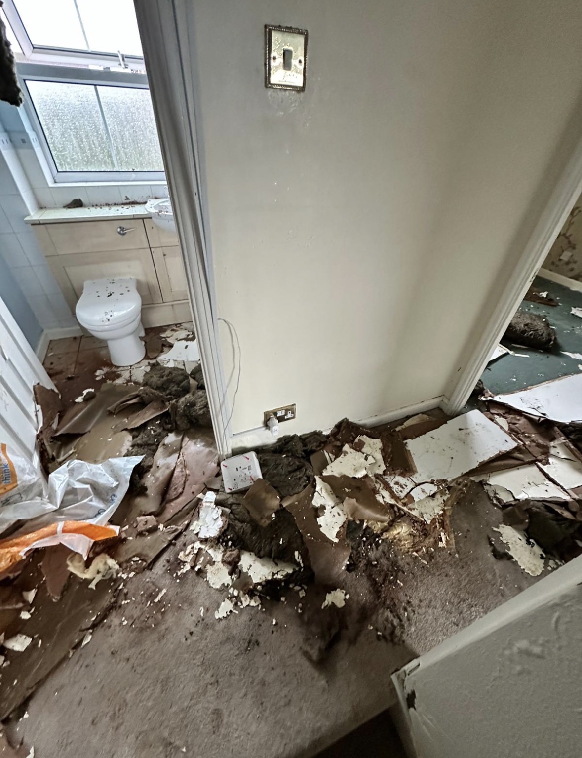 Landing area with exposed ceiling joists after removal of water-damaged plasterboard