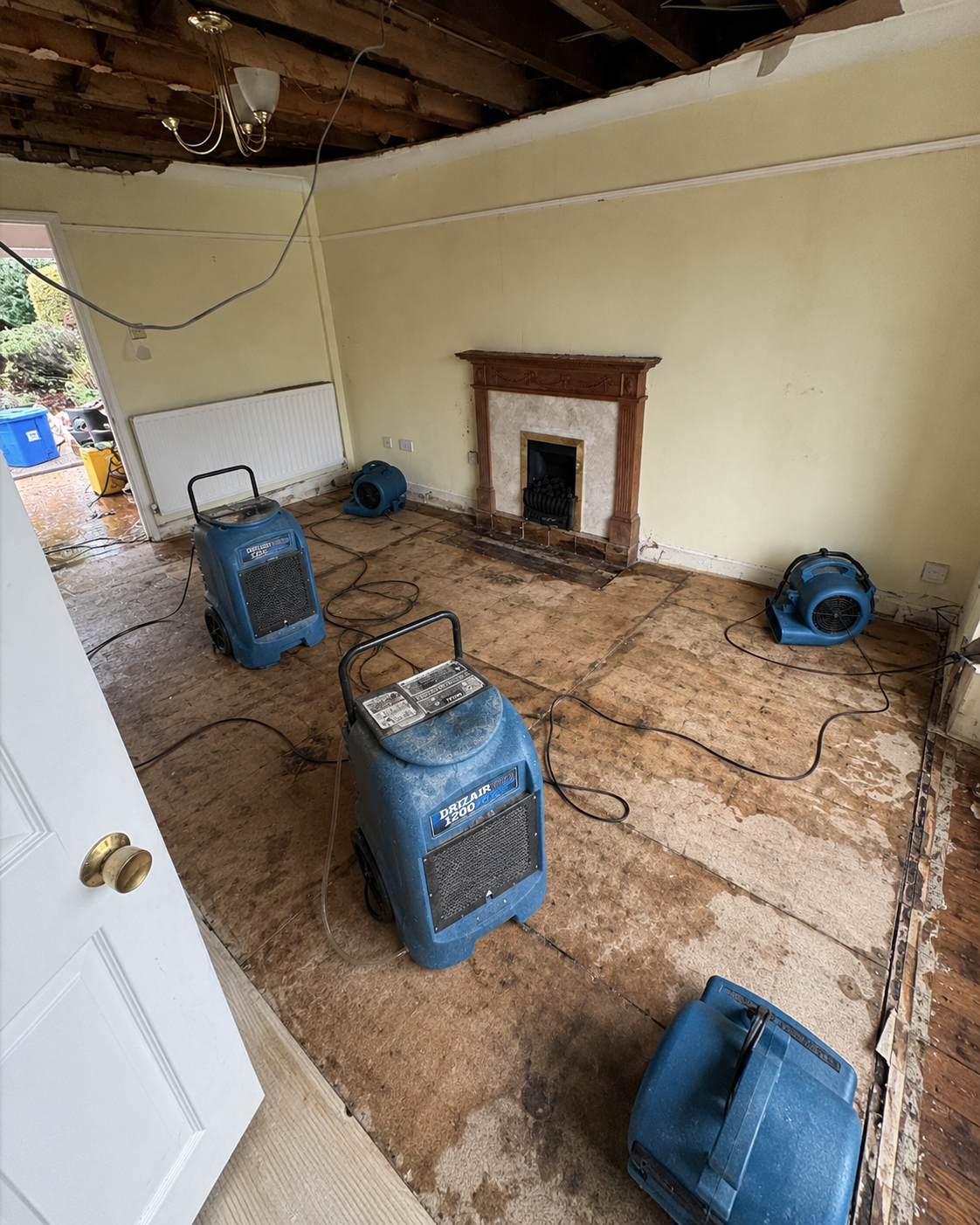 Living-room drying setup with hoses, cables and equipment in place